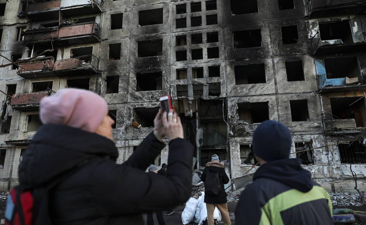 Una mujer fotografía un edificio destruido por un bombardeo de las tropas rusas.