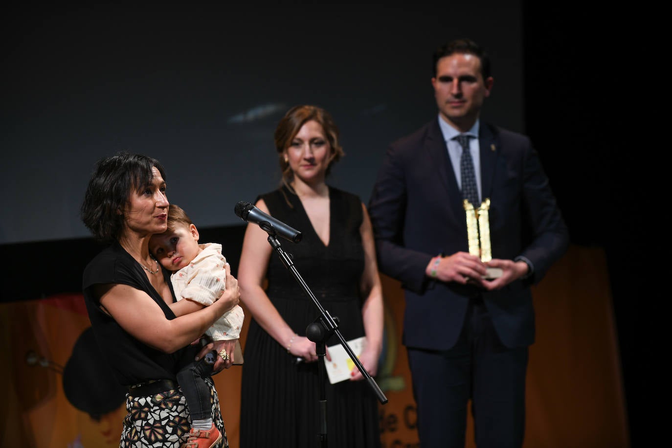 Amaia Remírez recogió el premio con su hijo en brazos y al lado, la concejala de Cultura, Cristina Aranda, y el alcalde, Guzmán Gómez.