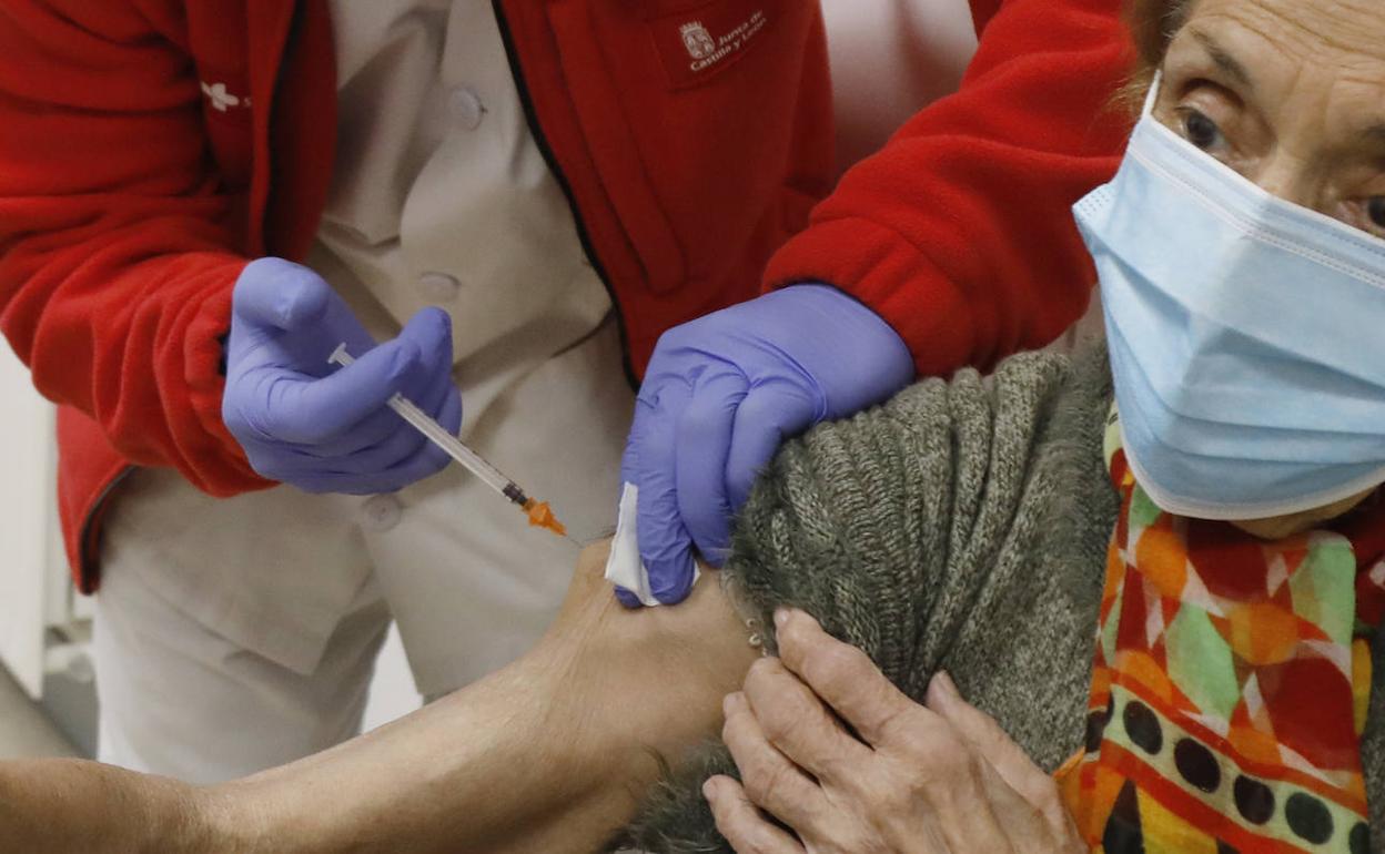 Una enfermera de Sacyl vacuna a una mujer en Palencia de la tercera dosis covid y de la gripe.
