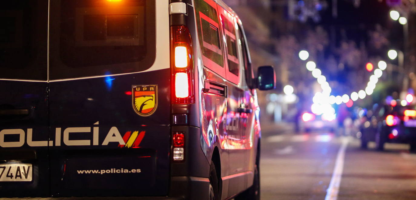 Un vehículo de la Policía Nacional patrulla por una calle durante la noche. 