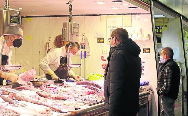 Varios clientes compran pescado en la Plaza de Abastos, este martes. 