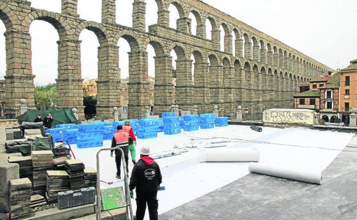 Obreros cubren con lonas la cubierta de Santa Columba en la renovación de la manta asfáltica. 