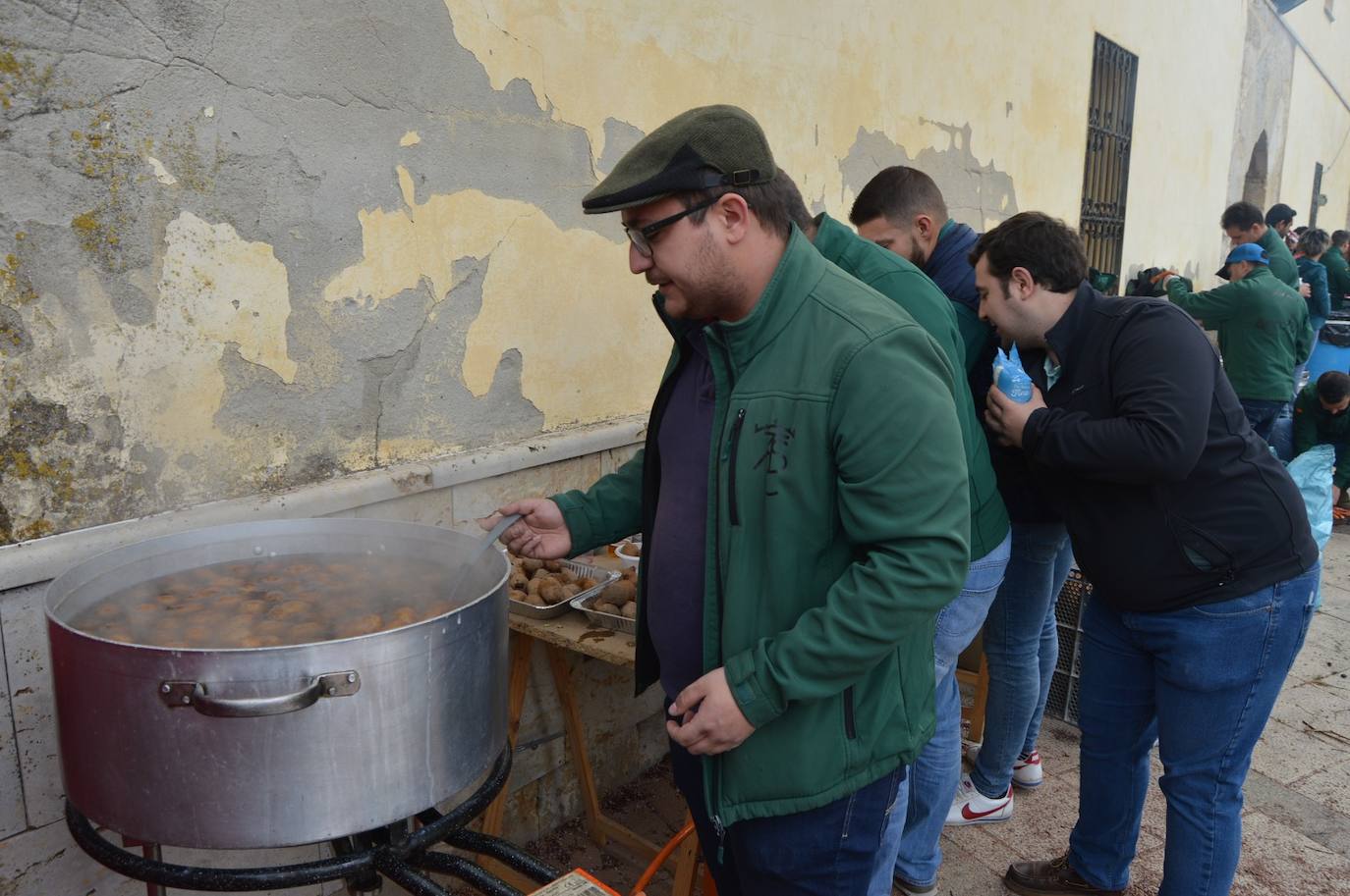 Uno miembro de la organización prepara uno de los platos que se han servido durante este sábado. / 