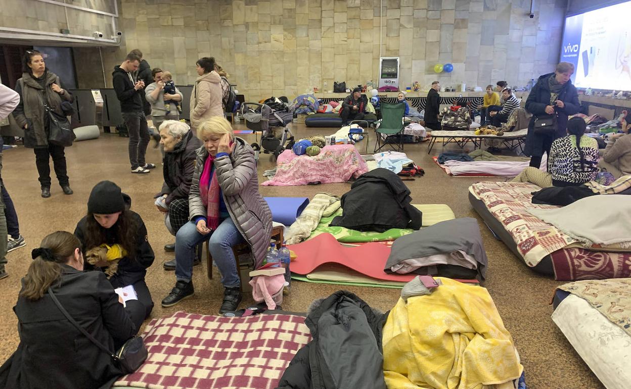 Varias personas permanecen en el interior de la estación de metro 'Héroes de Dnipra', este lunes en Kiev (Ucrania).