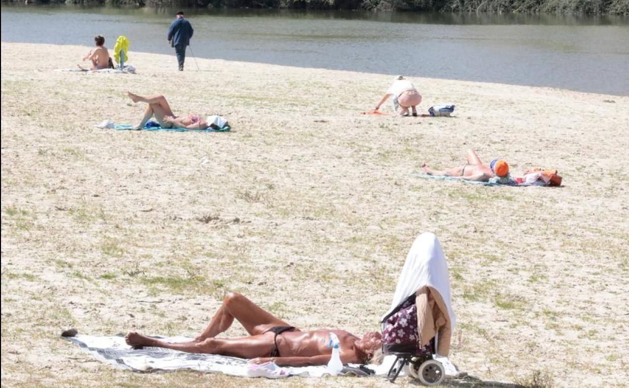 Varias personas toman el sol en la playa, ayer al mediodía. 