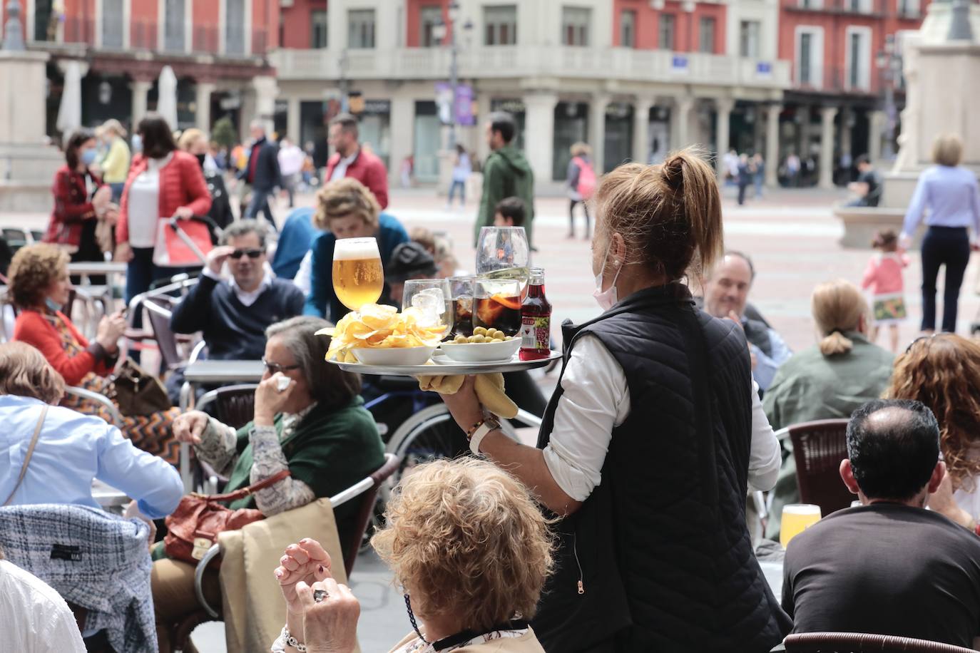 Una camarera atiende a los clientes en una terraza de la Plaza Mayor. 