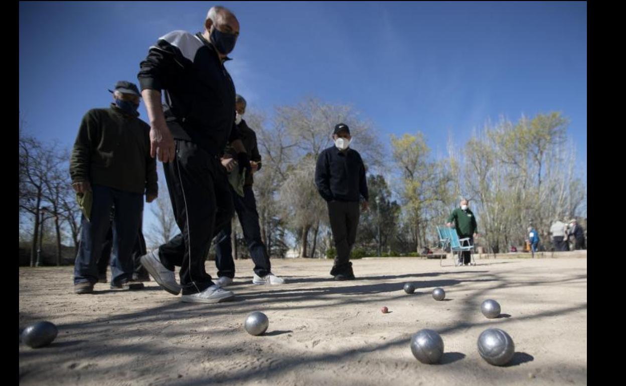 Jubilados juegan a la petanca en un parque vallisoletano.