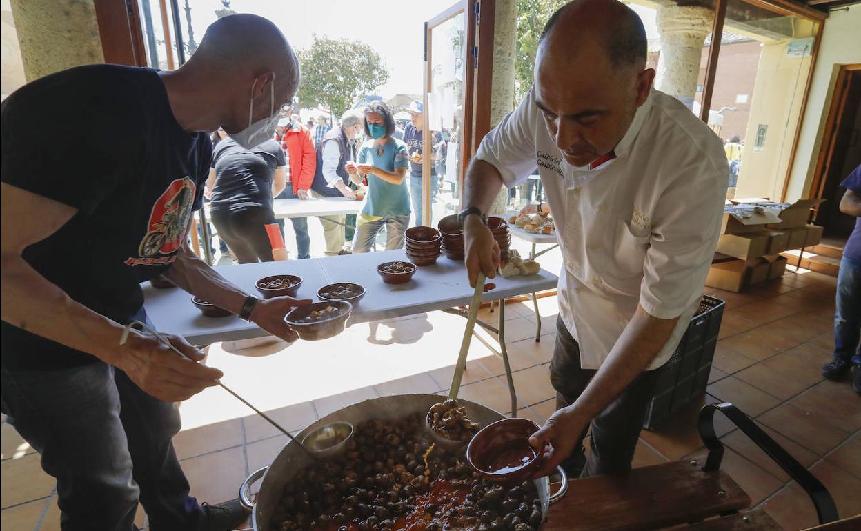 Los cocineros reparten las cazuelitas de caracoles.