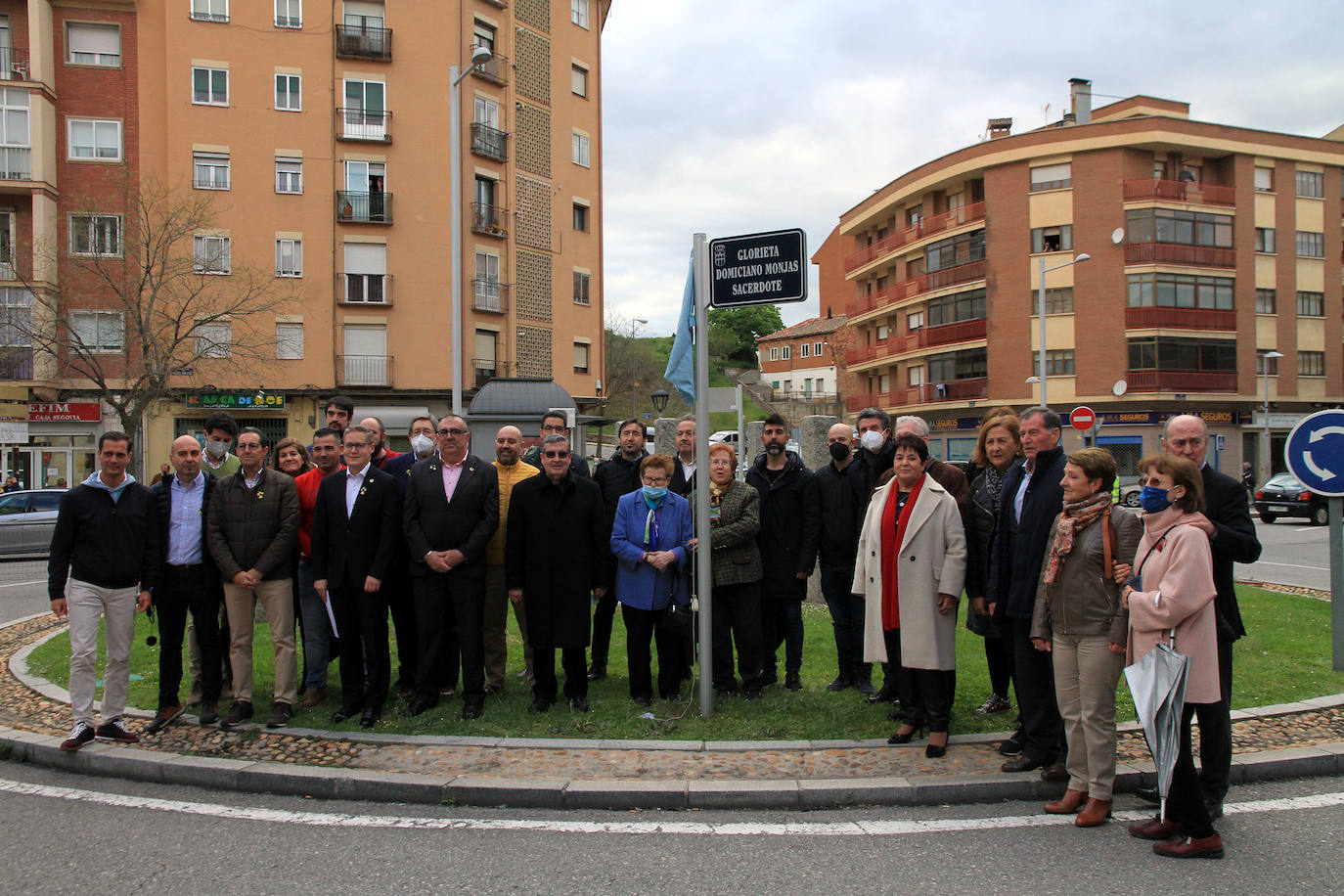 Autoridades y familiares de Domiciano Monjas posan tras descubrir la placa con el nombre del que fuera párroco del barrio.
