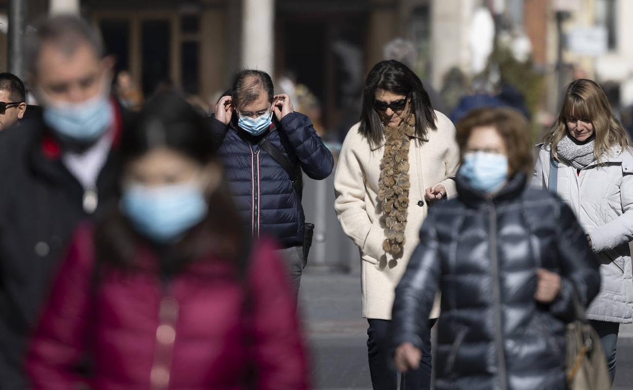 Un hombre se coloca la mascarilla por las calles de Valladolid, en una imagen de archivo. 