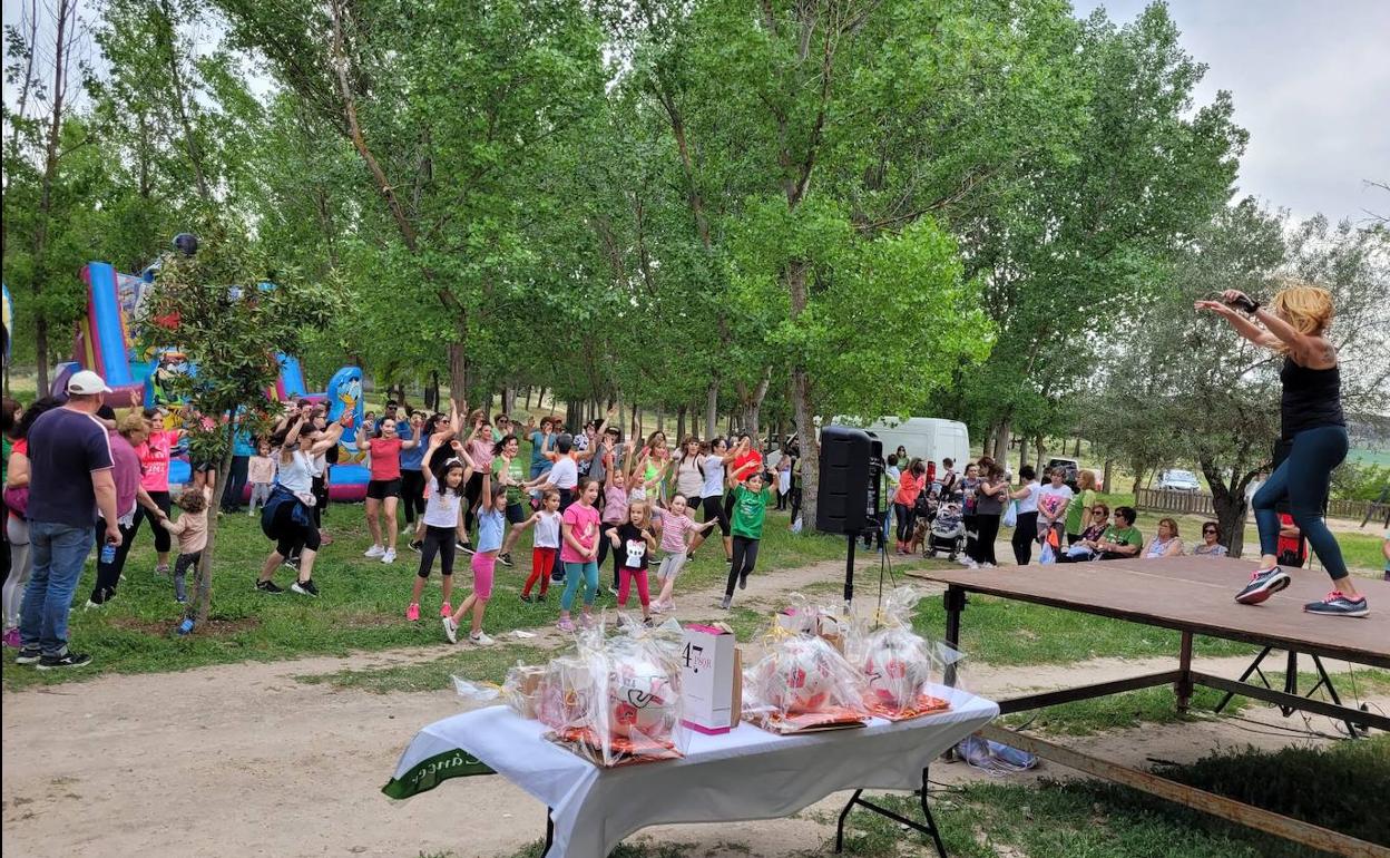 Participantes en la marcha contra el cáncer bailan en una sesión de zumba. 