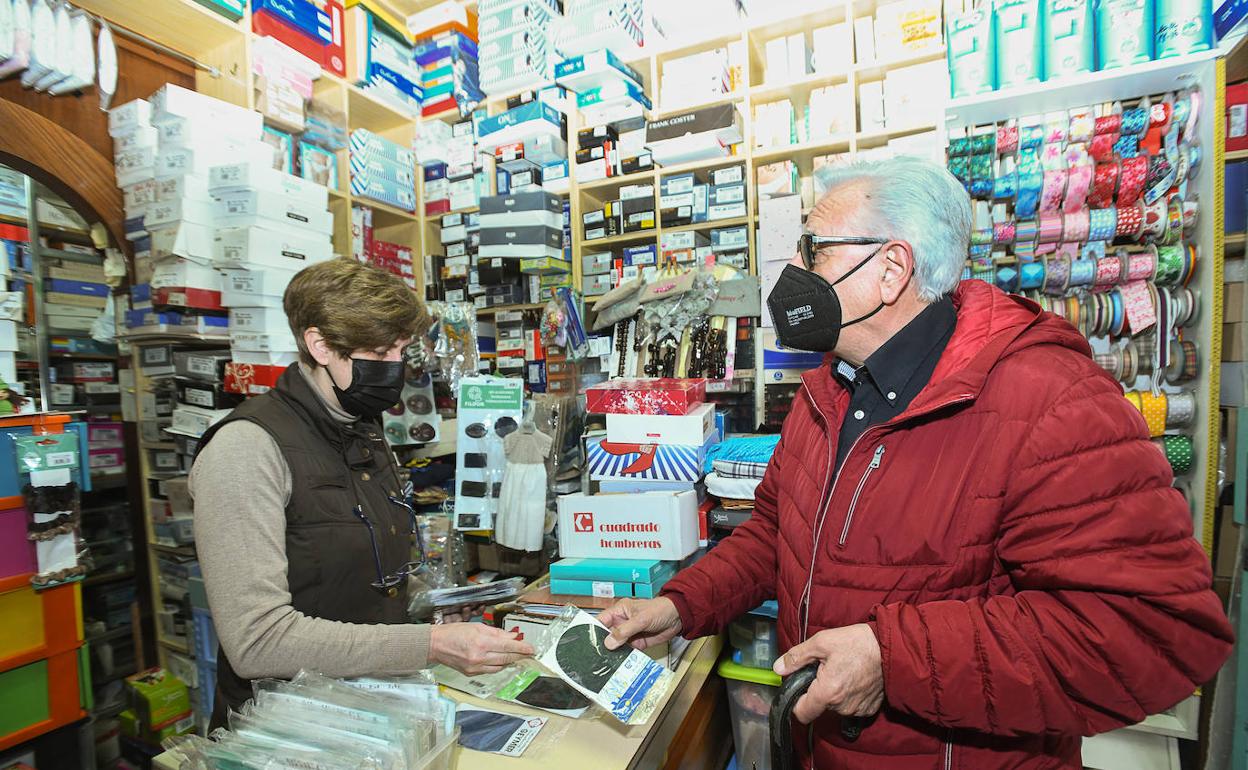 Usuarios con mascarilla en el interior de una farmacia. 