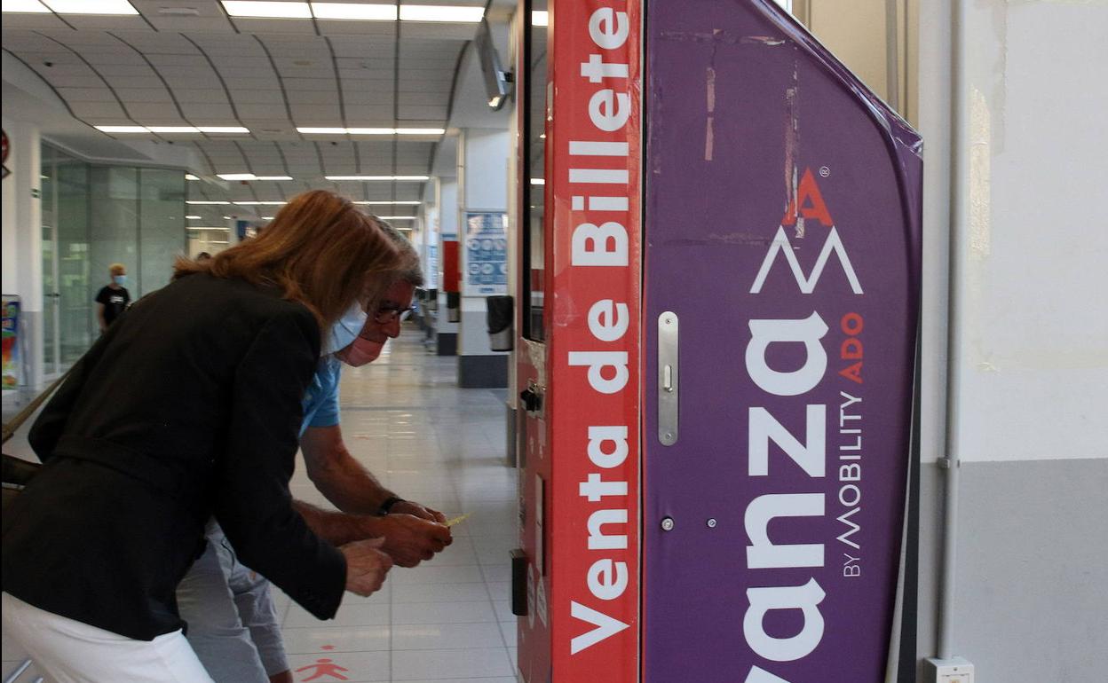 Unos usuarios tratan de comprar un billete para Madrid en una máquina de la concesionaria. 