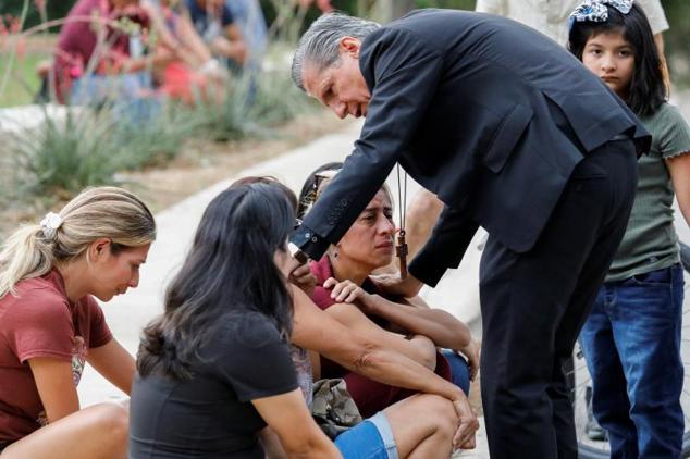 Un reverendo ofrece consuelo a las familias. 