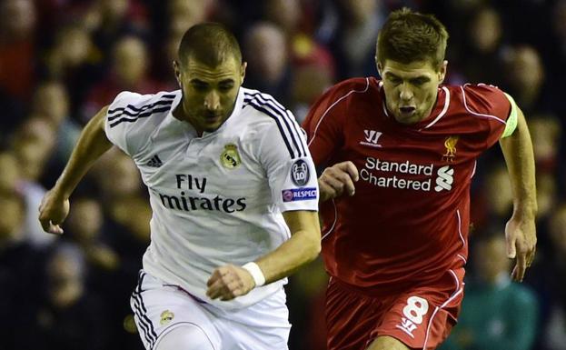 Steven Gerrard trata de alcanzar a Karim Benzema. 