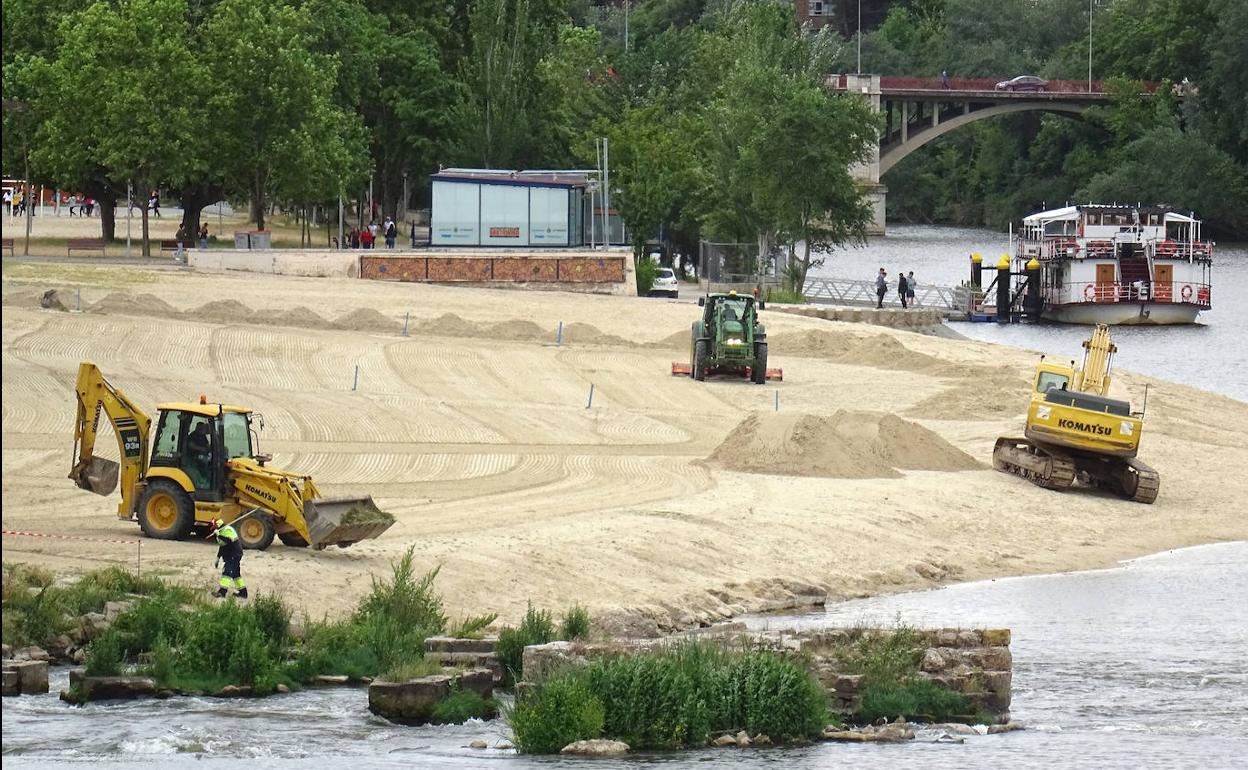 Las máquinas trabajan en la renovación de la arena de la playa de Las Moreras. 