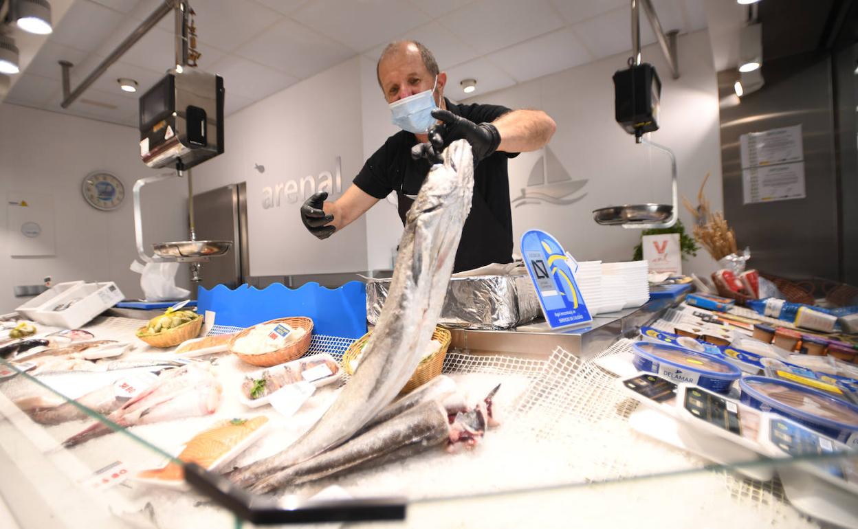 Eutiquio Arenal limpia un pescado en su establecimiento en el mercado del Val.