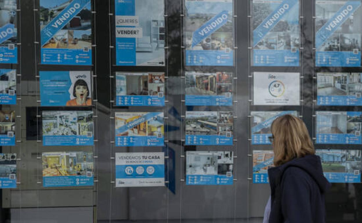 Una mujer observa el escaparate de una inmobiliaria en Santander. 