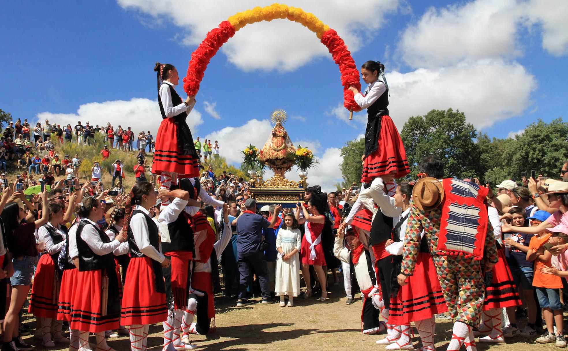 Castillo humano formado por danzantes de un grupo de paloteo sujetando un arco de flores bajo el que pasa la Virgen del Castillo en la Subida de este domingo. 