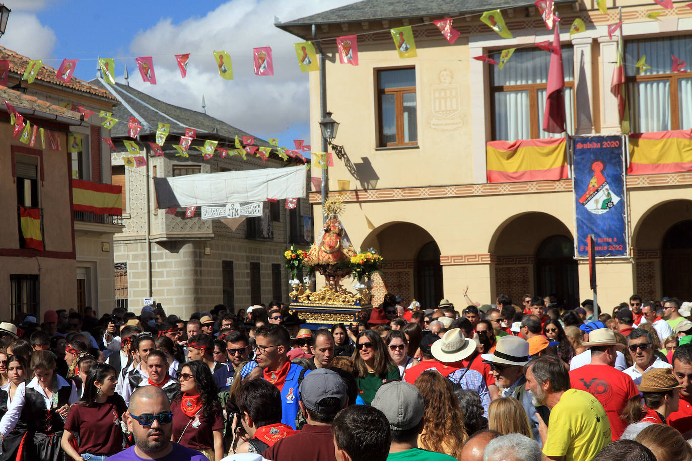 Los grupos de paloteo preceden el paso de la Virgen del Castillo por uno de los arcos de flores de papel en Bernardos. 