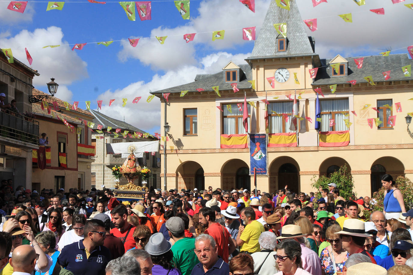 Los grupos de paloteo preceden el paso de la Virgen del Castillo por uno de los arcos de flores de papel en Bernardos. 