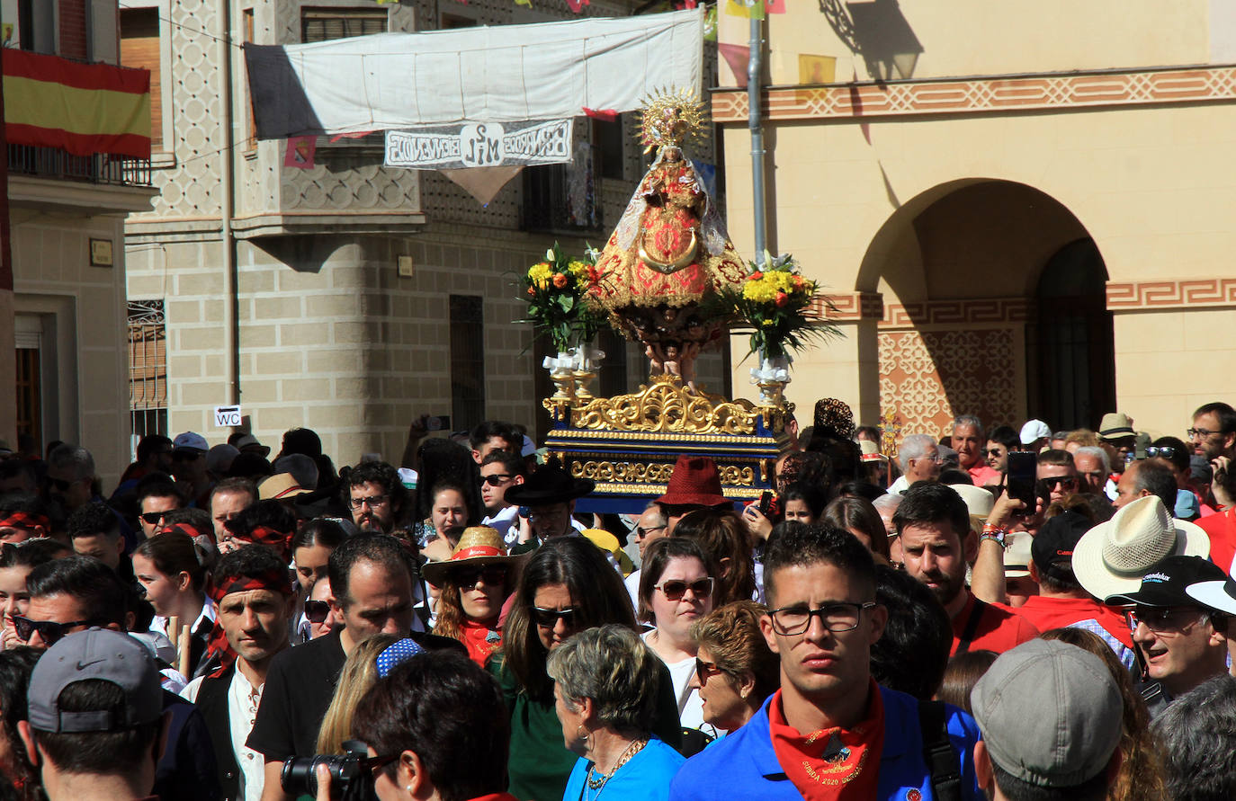 Los grupos de paloteo preceden el paso de la Virgen del Castillo por uno de los arcos de flores de papel en Bernardos. 