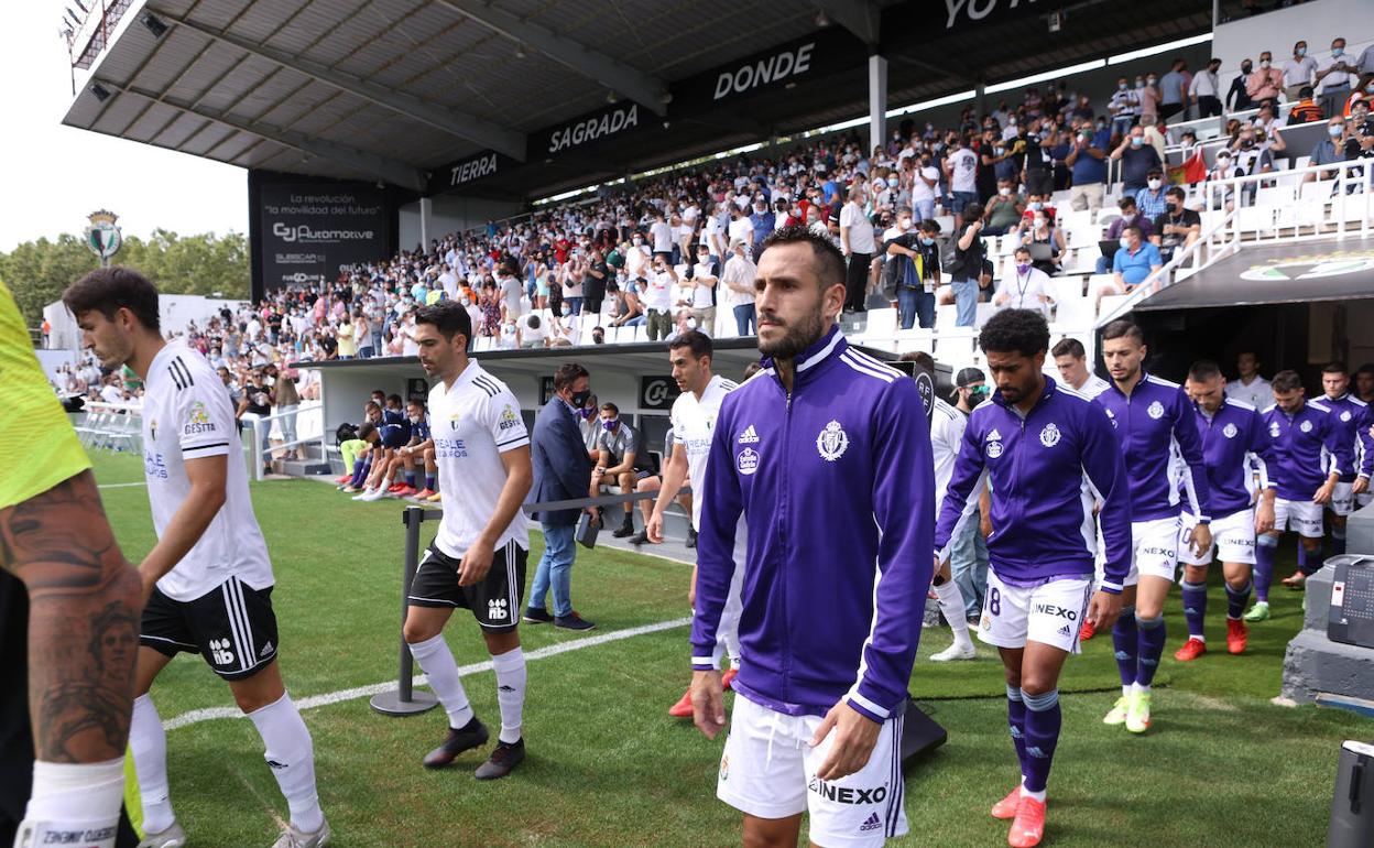 Los jugadores del Real Valladolid y el Burgos CF saltan a El Plantío en el partido de esta temporada. 