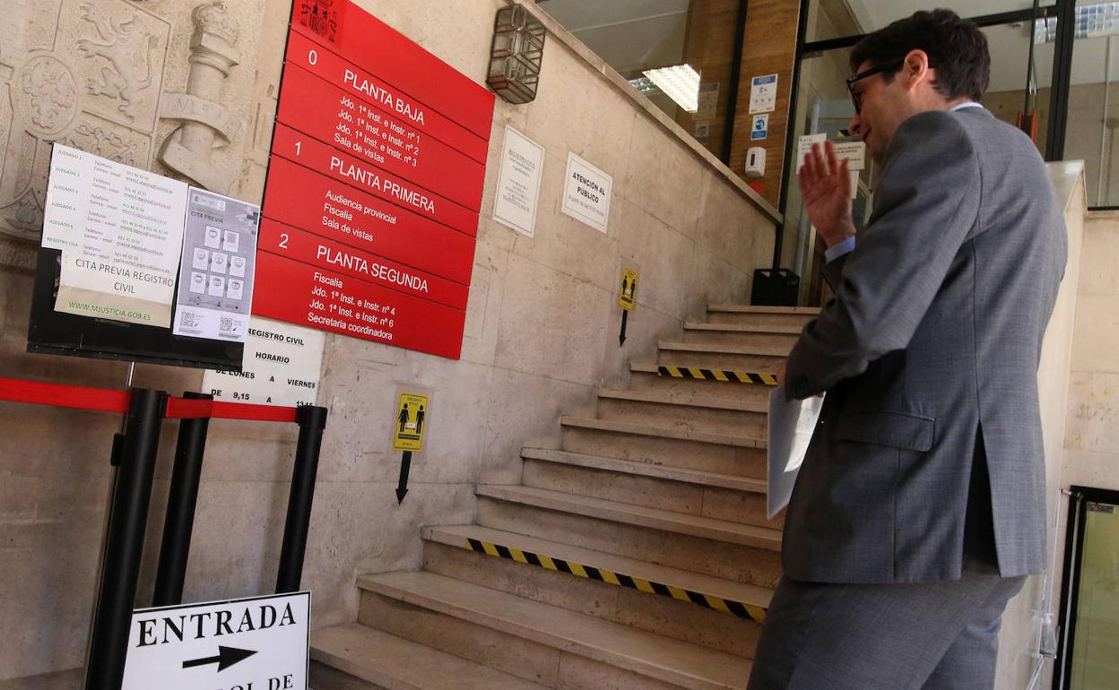 Un hombre consulta el panel de información sobre sedes judiciales a la entrada de la Audiencia Provincial de Segovia. 