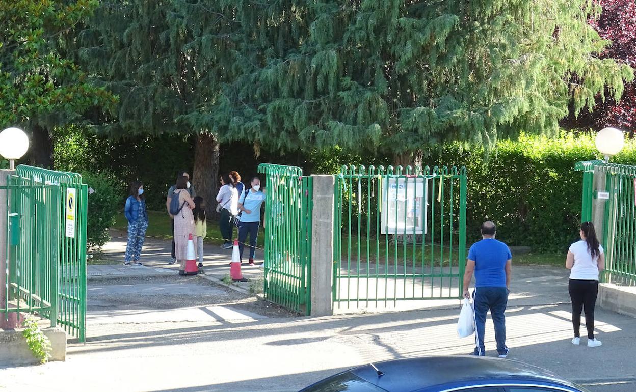 Los profesores reciben uno a uno a los alumnos tras la verja del colegio Jorge Guillén. 