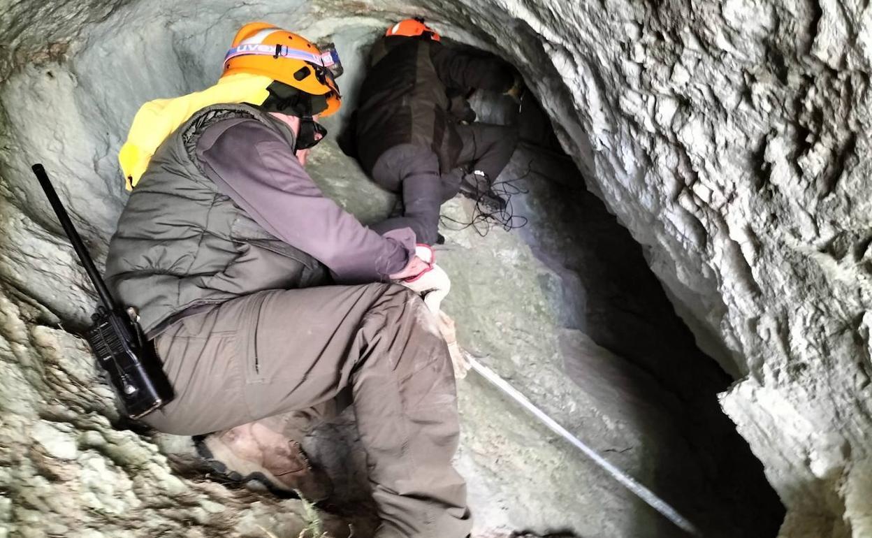 Dos expertos colocan los equipos de monitorización a la entrada de la cueva.