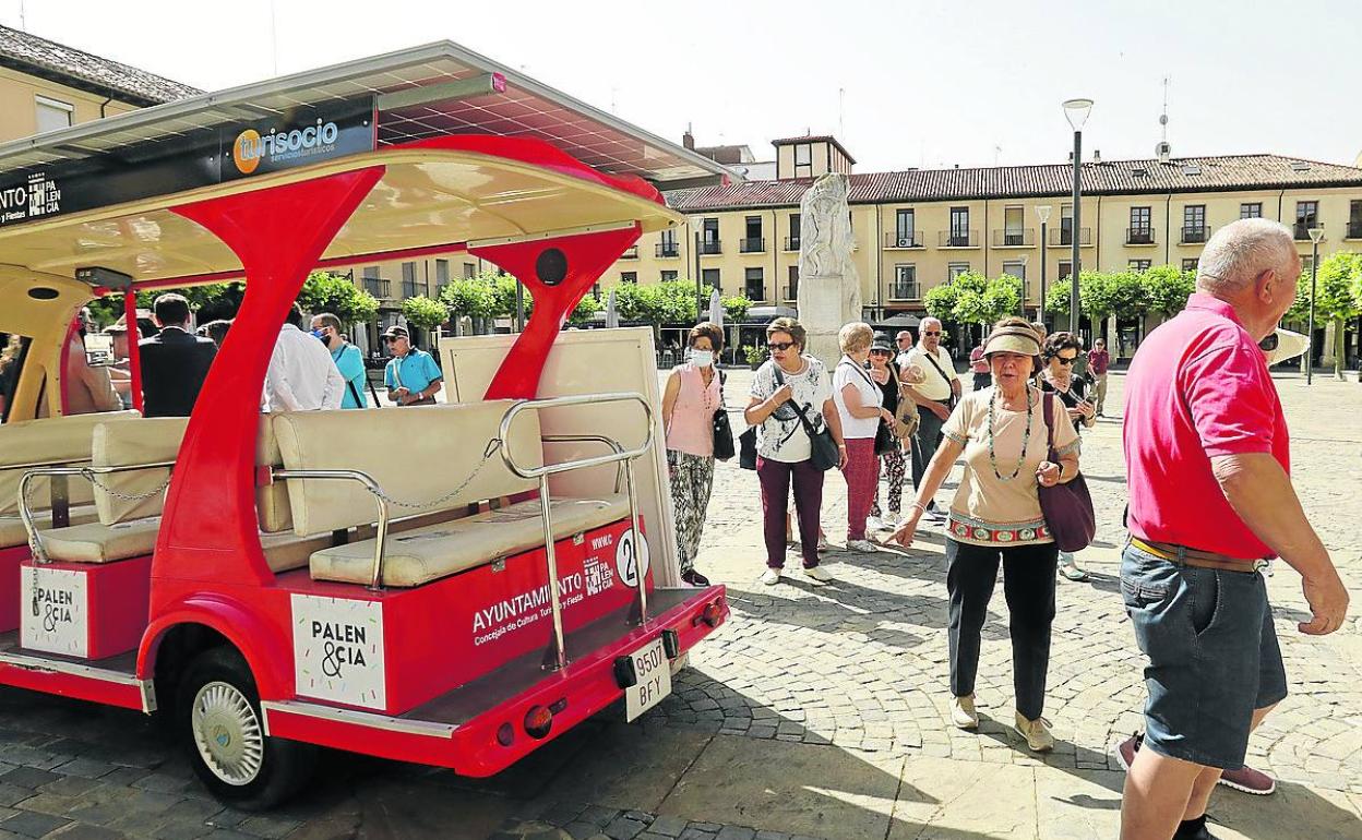Un grupo de turistas observa el nuevo microbús aparcado en la Plaza Mayor.