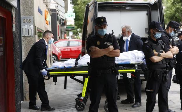 Miembros del servicio funerario retiran uno de los cuerpos. 