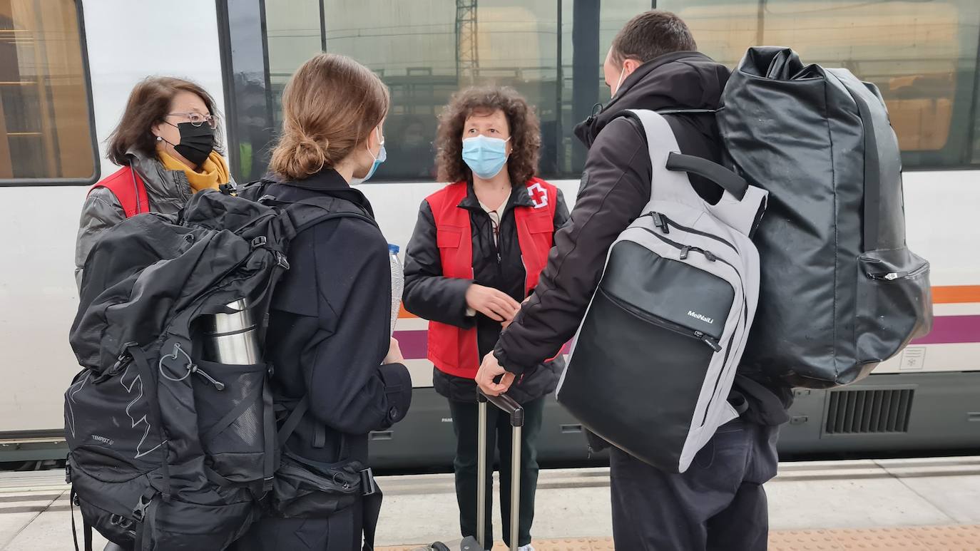 Personal de Cruz Roja atiende en la estación de tren Campo Grande a dos refugiados en tránsito. 