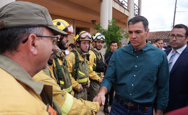 El presidente del Gobierno, Pedro Sánchez, saluda a un grupo de brigadas anti incendios en el ayuntamiento de Otero de Bodas durante su visita a las zonas afectadas por el incendio forestal de la Sierra de la Culebra. 