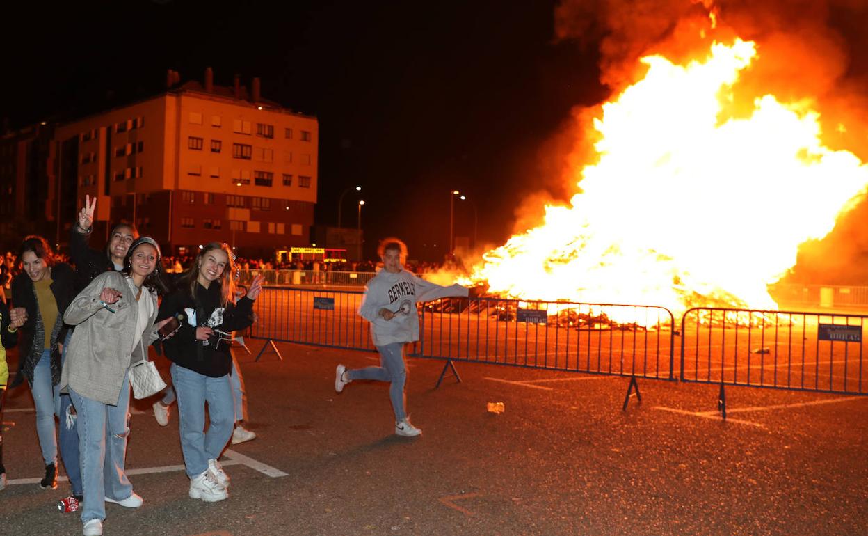 Unas jóvenes se fotografían junto a la hoguera de San Juan.