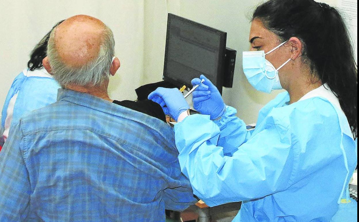 Una enfermera pone una dosis de la vacuna contra la covid un hombre en las pasadas campañas. 