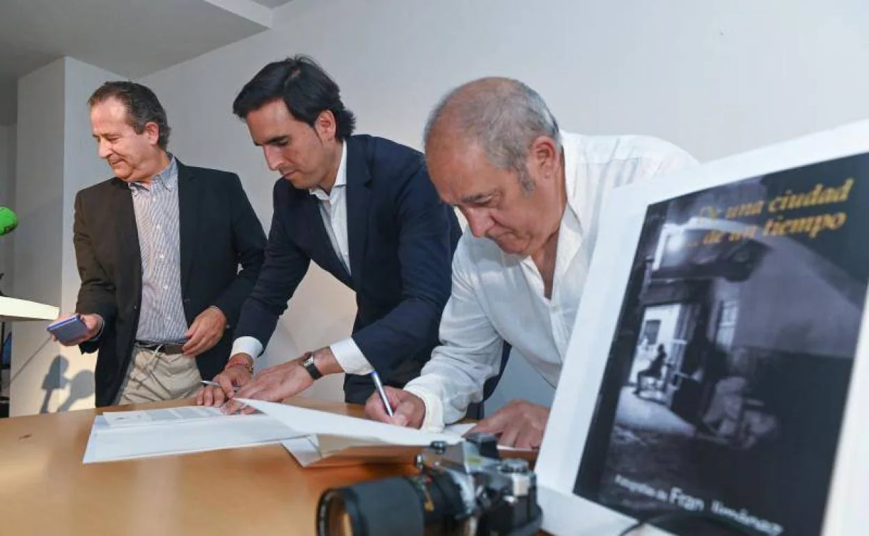 El alcalde de Medina, Guzmán Gómez, (centro) y el fotógrafo Fran Jimenez (derecha) firman el acta de cesión del millón y medio de imágenes en presencia del director del Museo de las Ferias, Antonio Sánchez del Barrio.