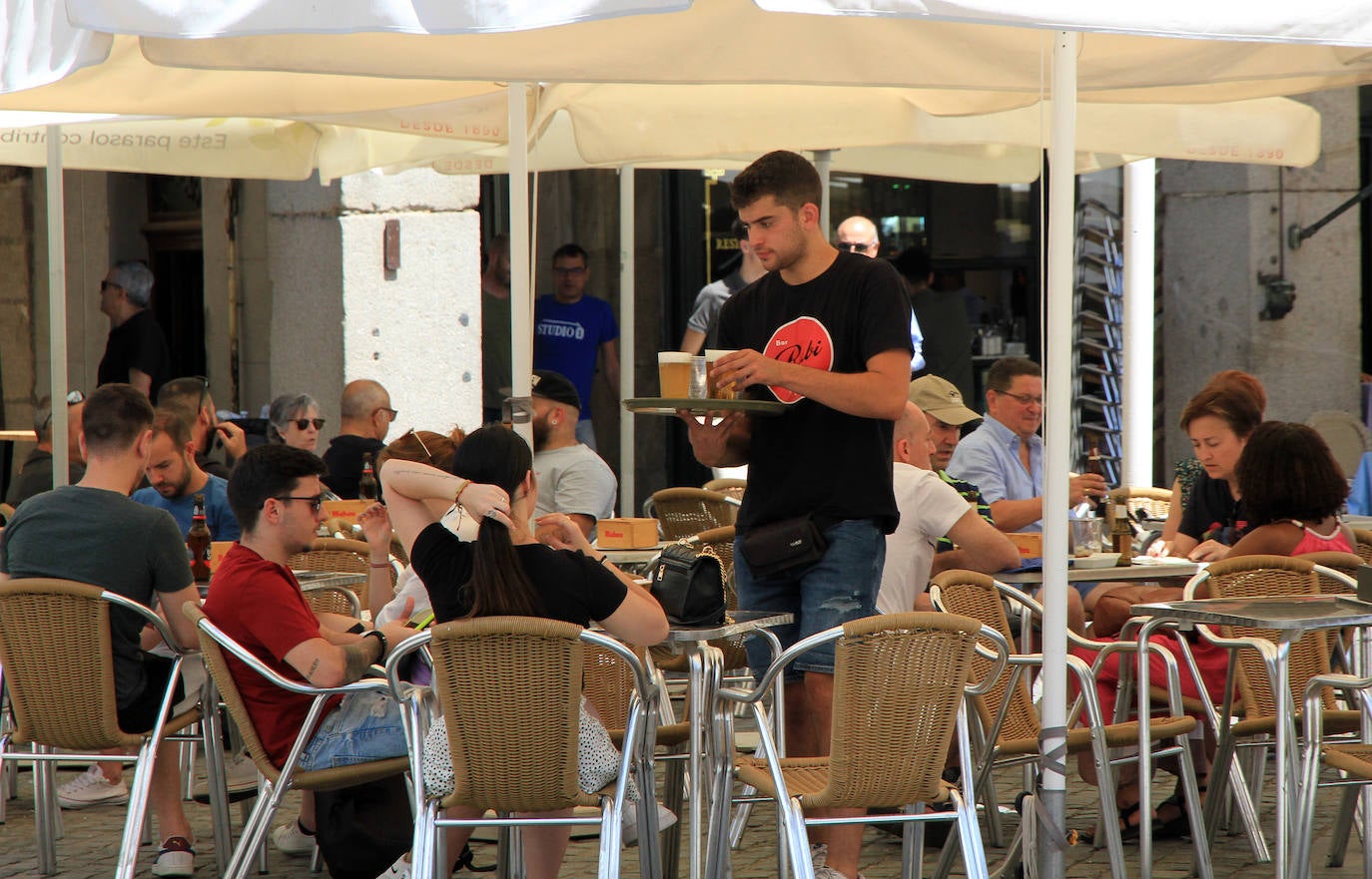 Un camarero sirve una mesa en una terraza de Segovia.