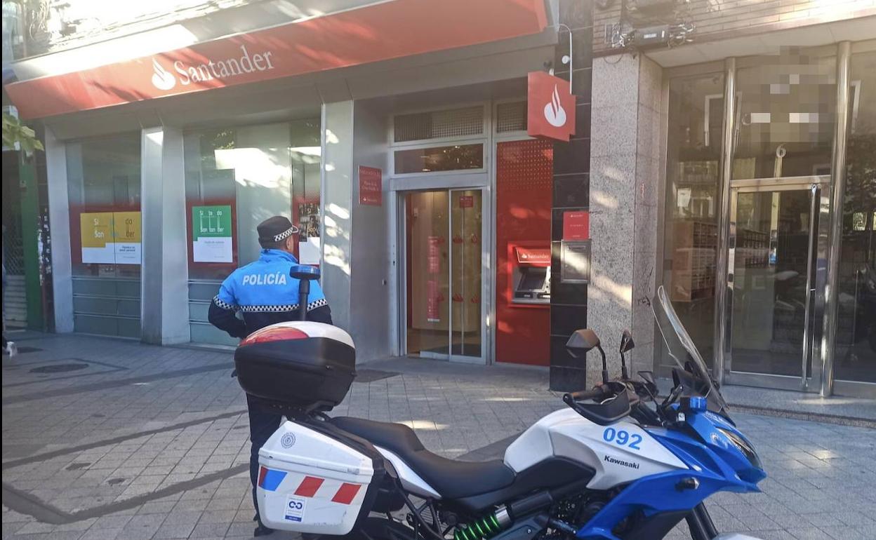 Un agente, ante la oficina del Santander de la Cruz Verde, donde fue detenida la sospechosa. 