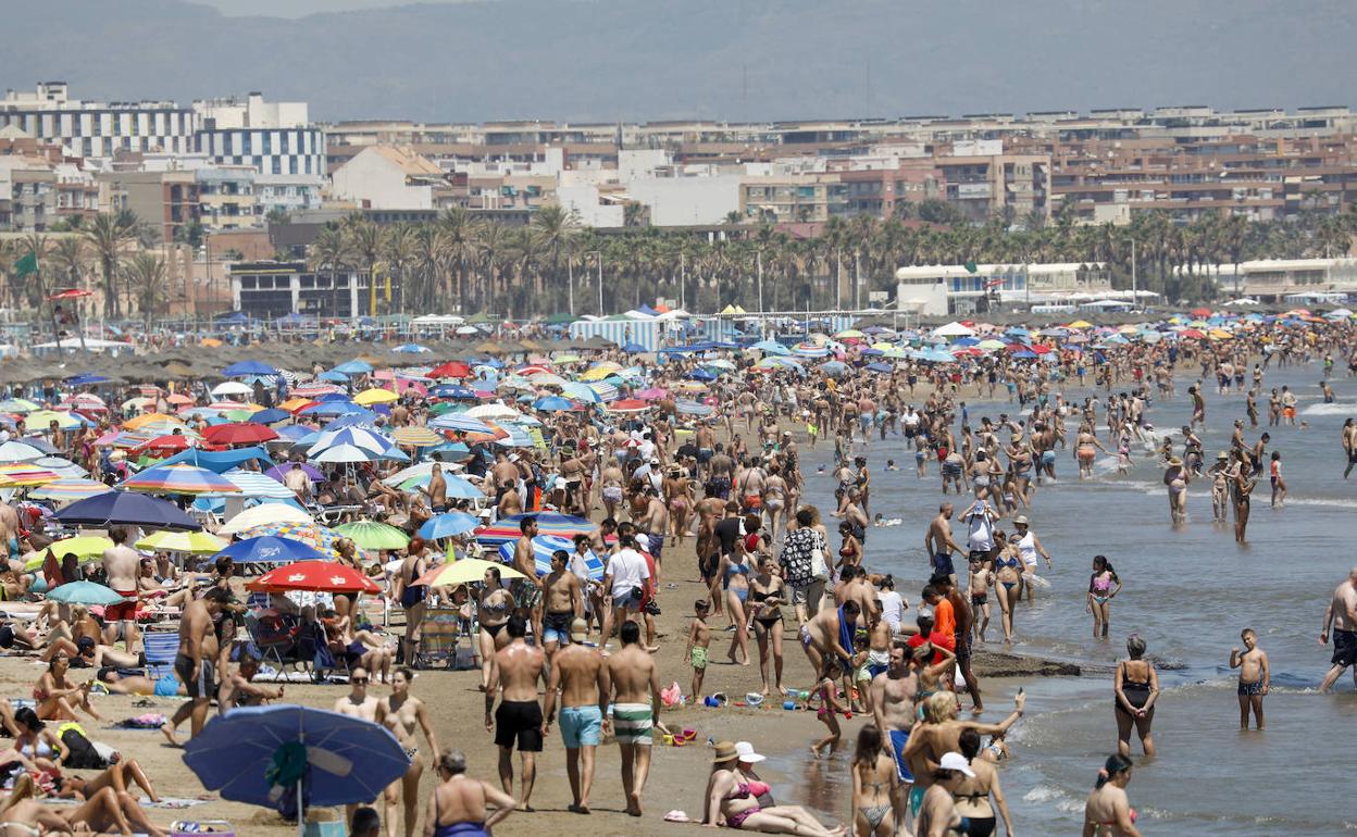 Una playa llena de personas en plena ola de calor en España.