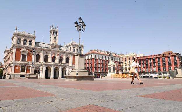 La Plaza Mayor completamente desierta, salvo por una mujer que la atraviesa. 