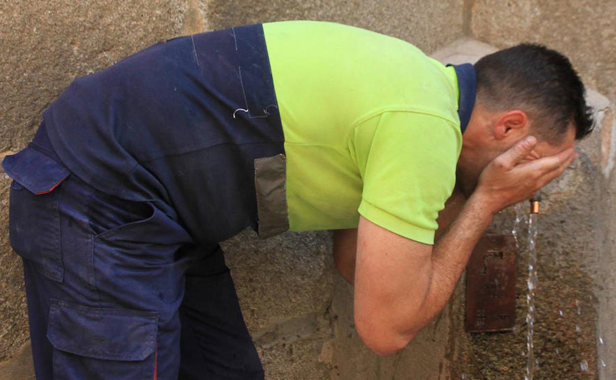 Un trabajador se refresca la cara en una fuente de la capital segoviana este jueves. 