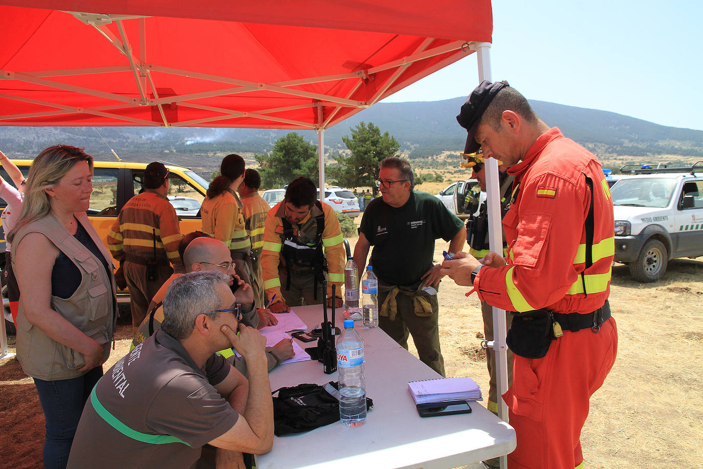 La UME (derecha) toma nota del estado del incendio de Navafría, a primera hora de la tarde, en el centro de mando de Santiuste de Pedraza.