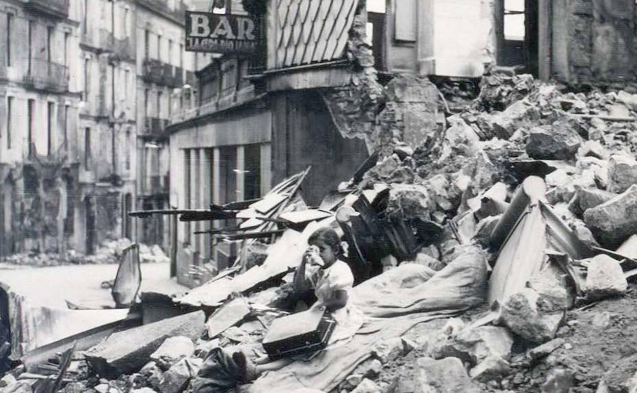 Una niña, con una maleta y su peluche, entre los escombros de una casa, en una fotografía fechada el 23 de septiembre de 1939. 