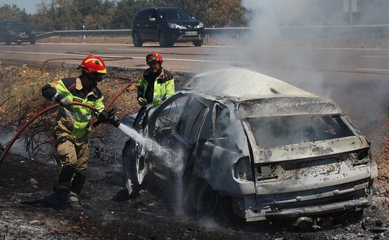 Los bomberos apagan el coche incendiado en la provincia salmantina. 