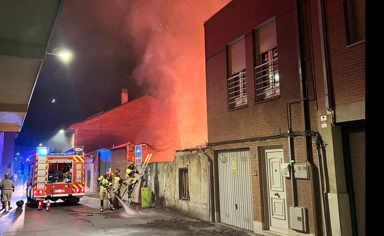 Varios bomberos de Valladolid tratan de sofocar las llamas del interior del solar. 