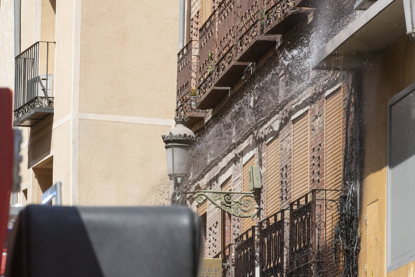 Bomberos acceden al edificio donde ha tenido lugar el incendio tras soficar las llamas en el exterior. 