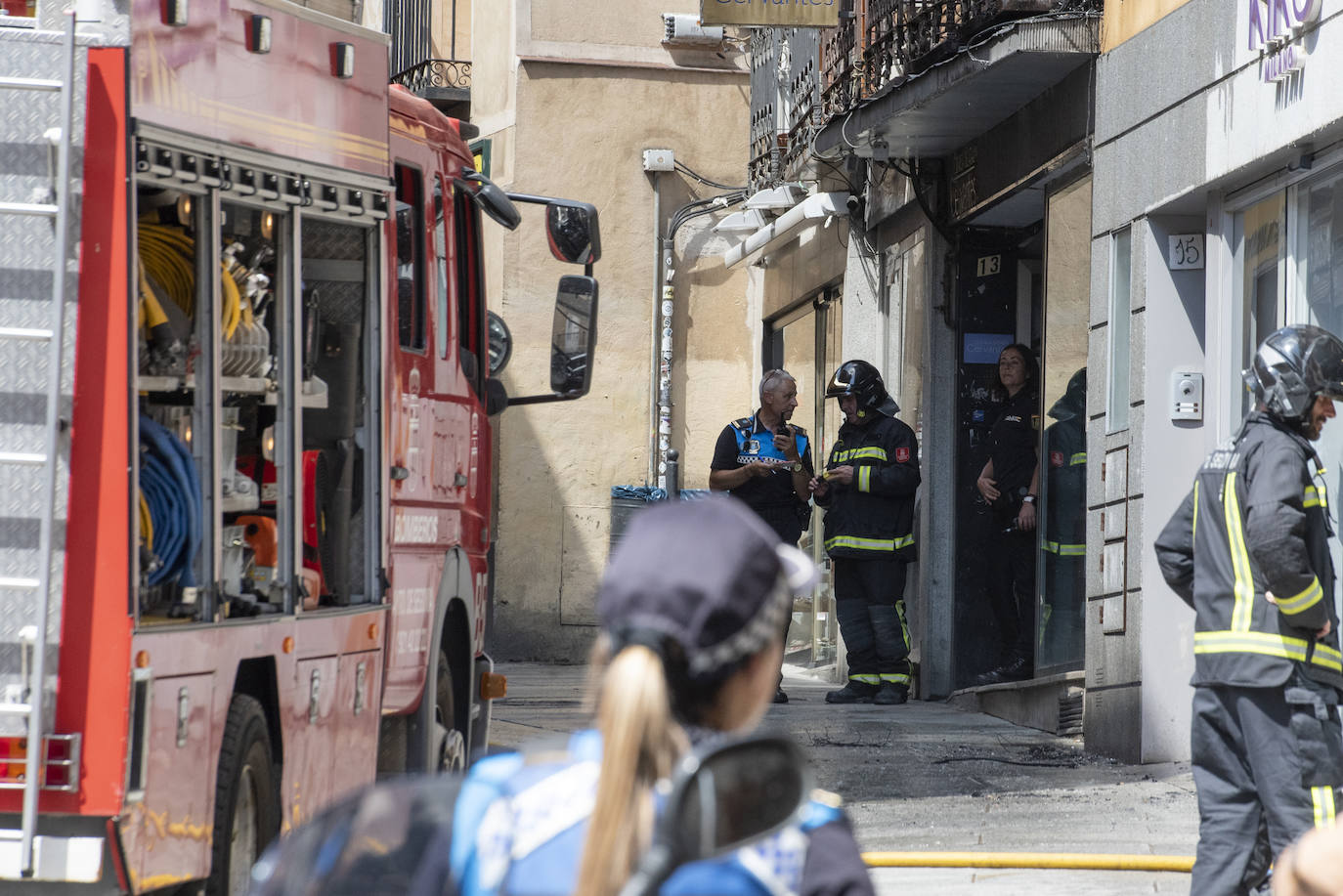 Bomberos acceden al edificio donde ha tenido lugar el incendio tras soficar las llamas en el exterior. 