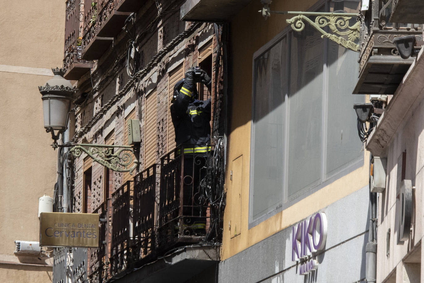 Bomberos acceden al edificio donde ha tenido lugar el incendio tras soficar las llamas en el exterior. 