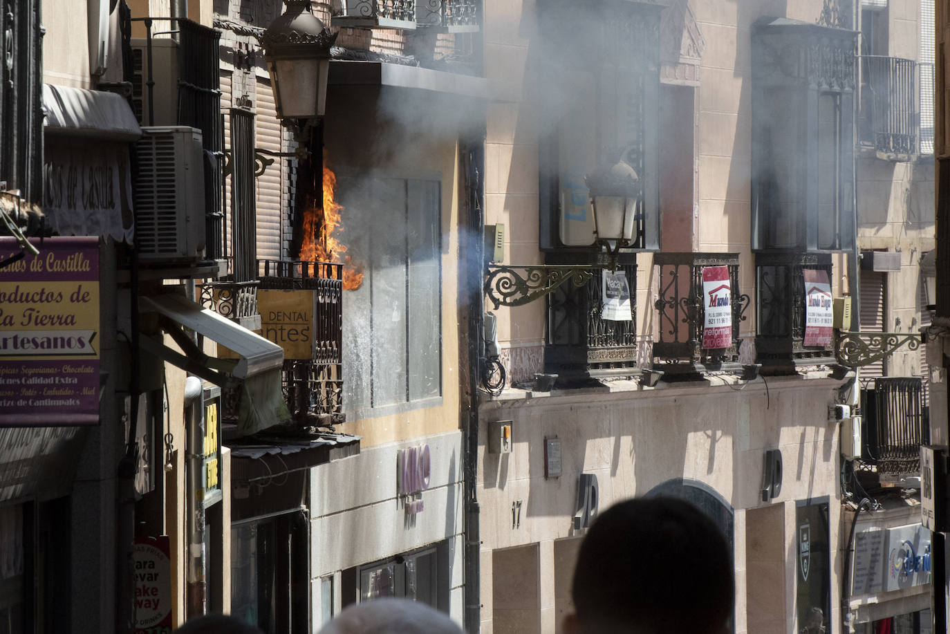 Bomberos acceden al edificio donde ha tenido lugar el incendio tras soficar las llamas en el exterior. 